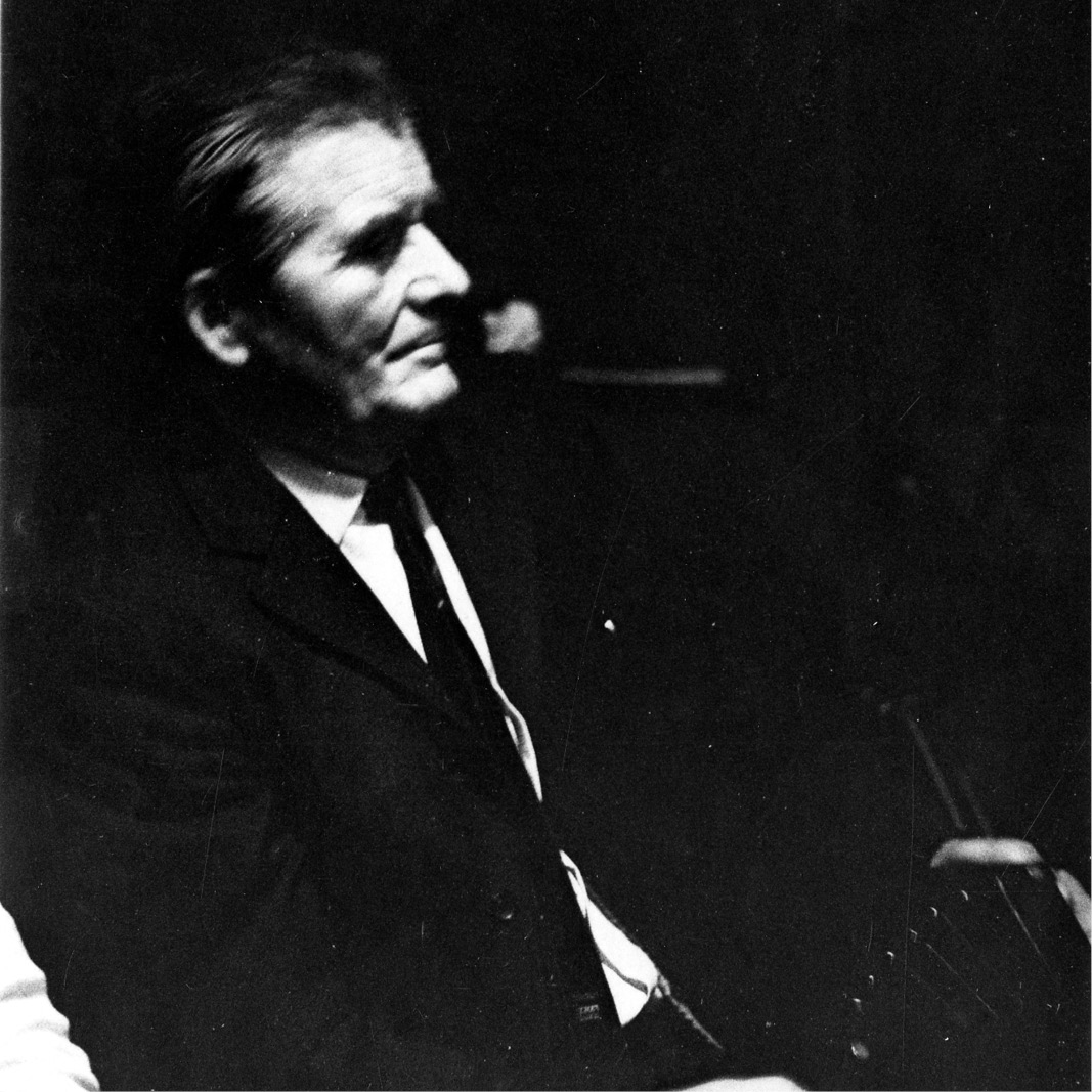Black and white photo of a man sitting in a suit