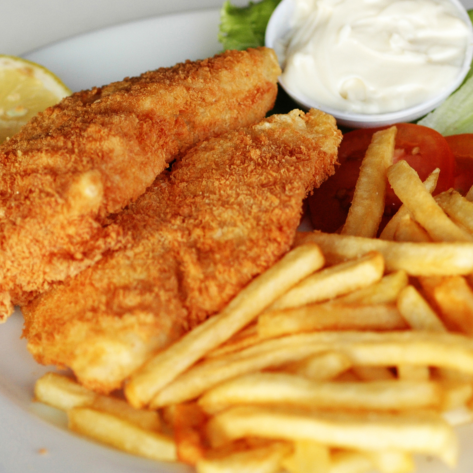 Panert trosk med pommes frites, majonesdip og grønnskaker til pynt