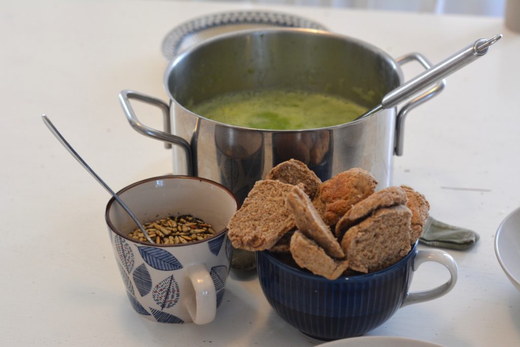 Grön ärtsoppa med topping av rostade solrosfrön och hembakta kalljästa frallor.