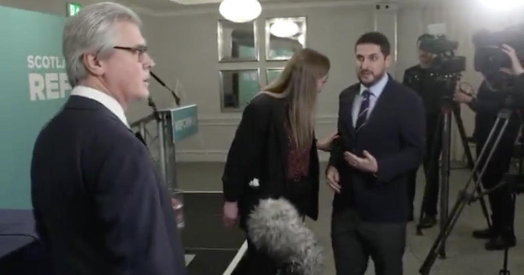 A Reform staffer manhandles a journalist during interview with Malcolm Offord