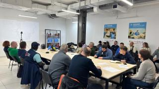 Participants sitting around table in a meeting in Ukraine