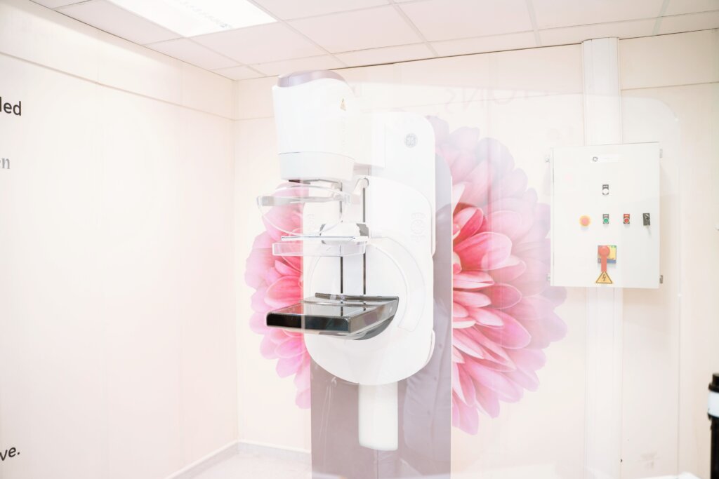 A modern mammography machine set against a backdrop featuring a large pink flower. The clean and well-lit room highlights the advanced medical equipment, which is part of the comprehensive healthcare services provided by Marcelle Ruth.