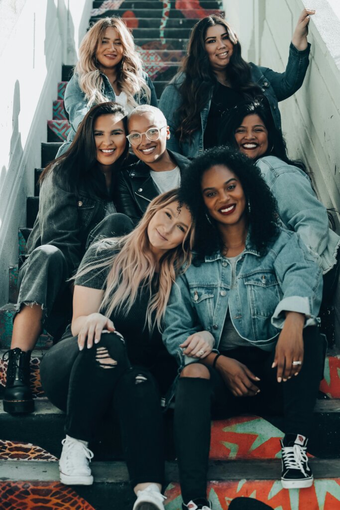 A group of women sitting together and smiling by Joel Munoz via Unsplash