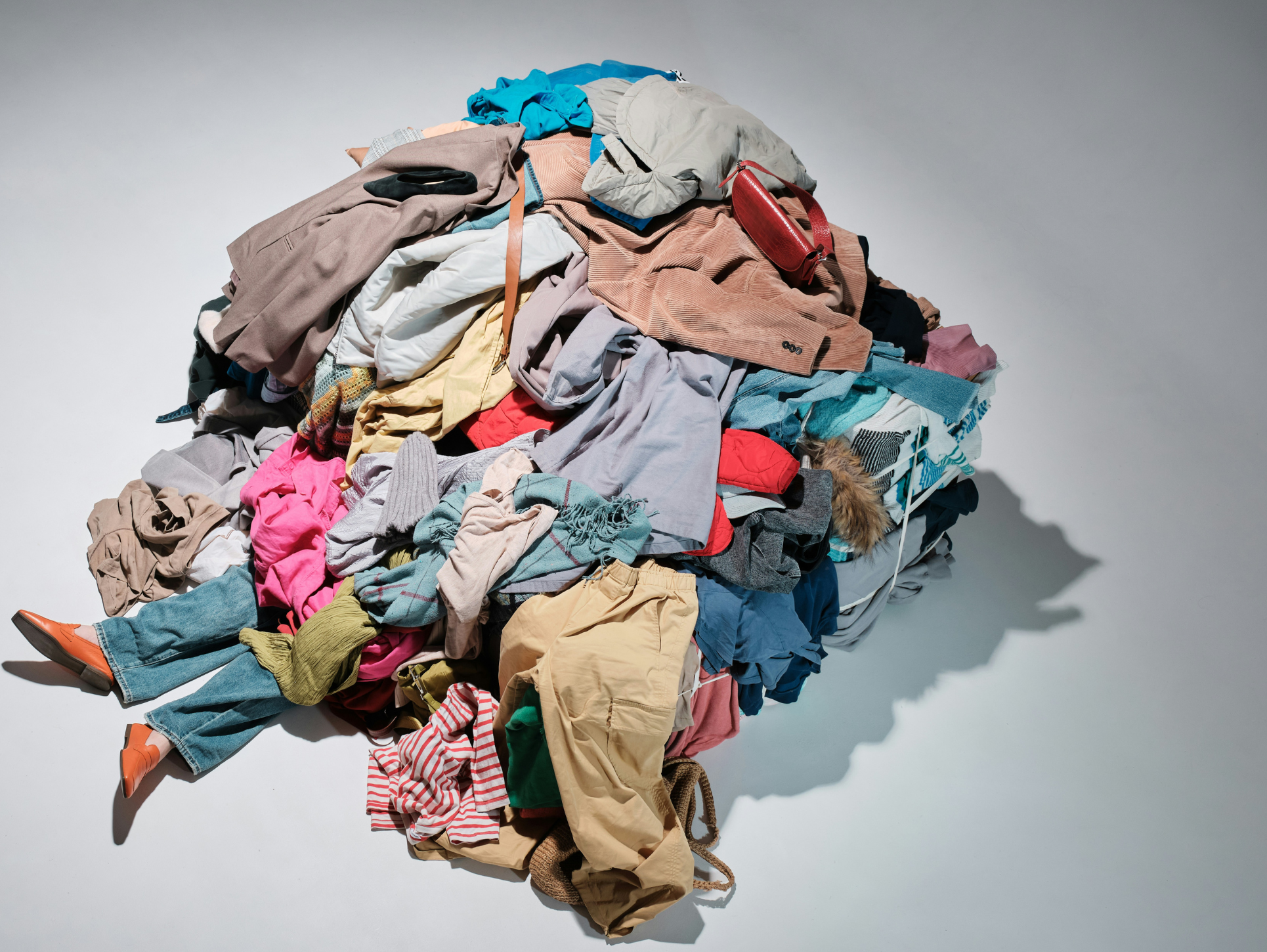 A shot of model under mountains of clothing by Andrej Lišakov via Unsplash+