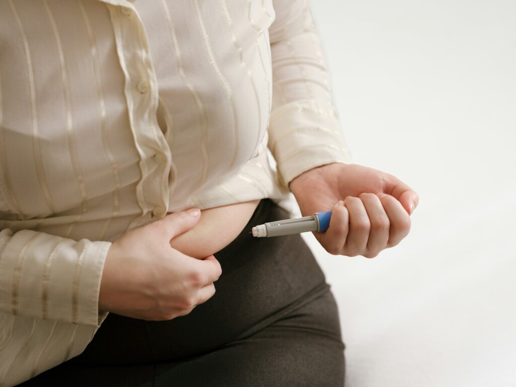 A woman injecting her abdomen with Ozempic by Getty Images via Unsplash+