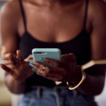 A black woman using a phone via Getty Images