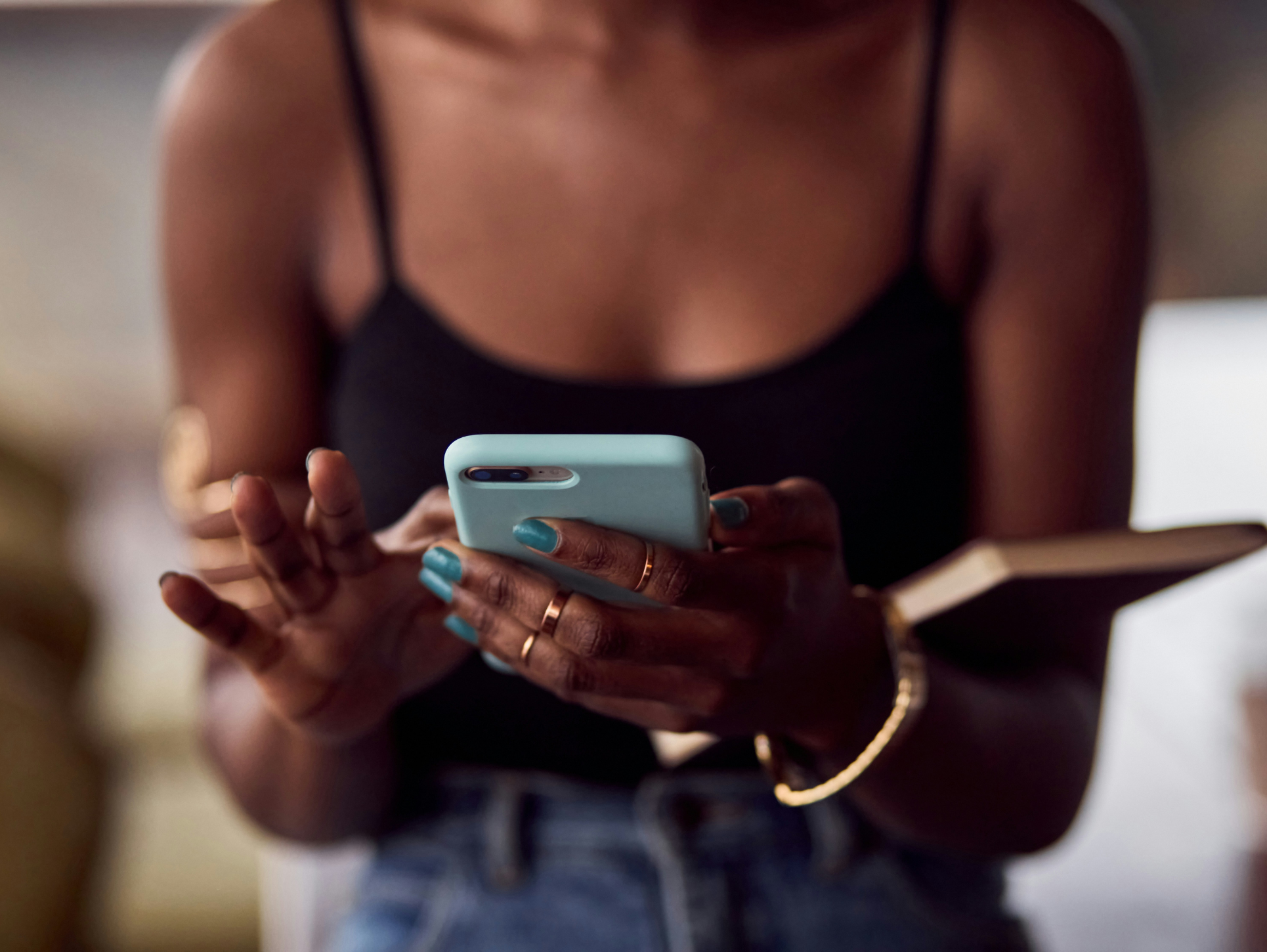 A black woman using a phone via Getty Images