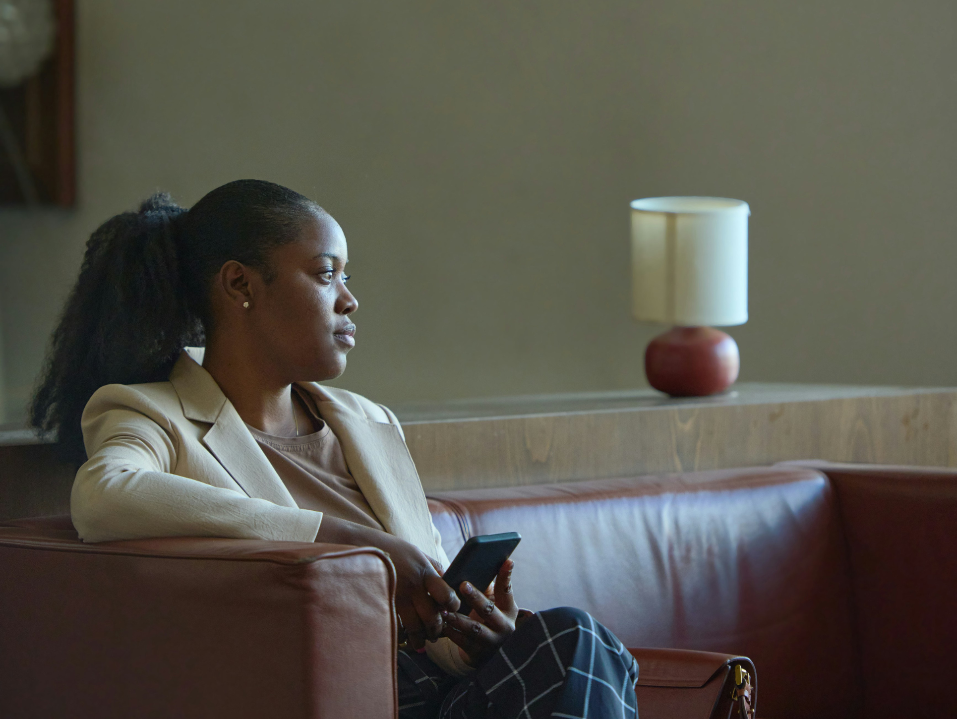 A black woman sitting alone looking forlorn via Getty Images from Unsplash+