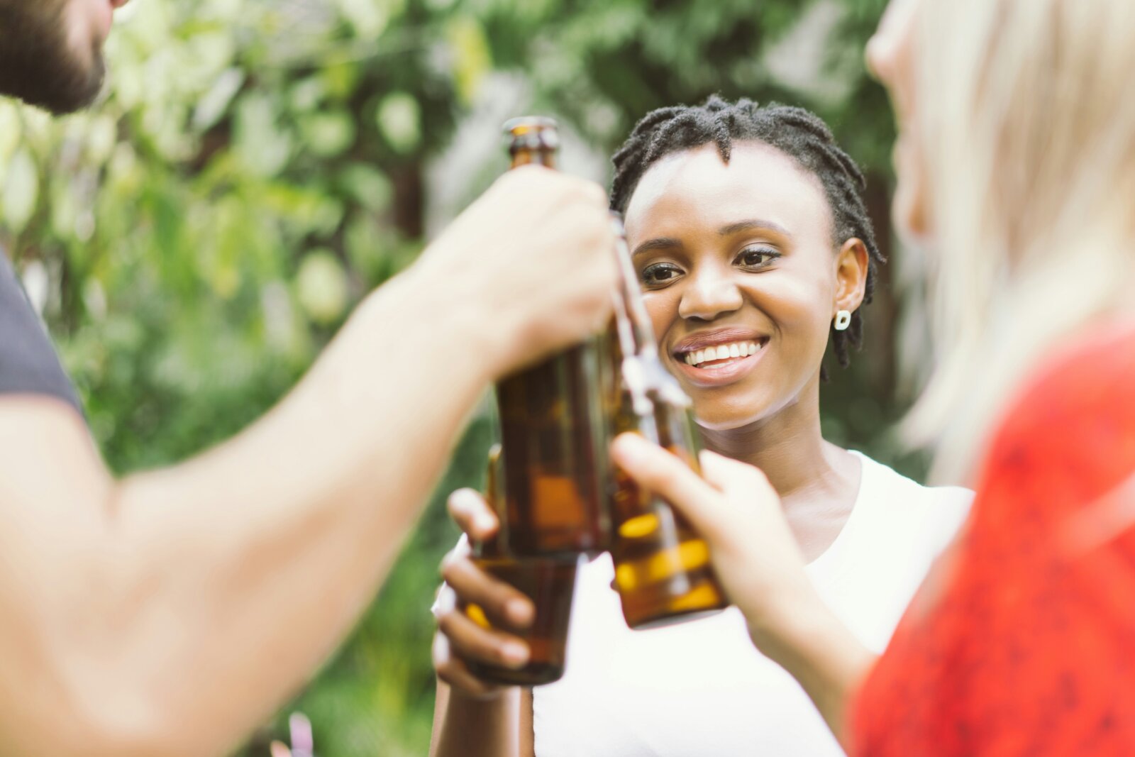 A group of people toasting with beer bottles via Getty Images