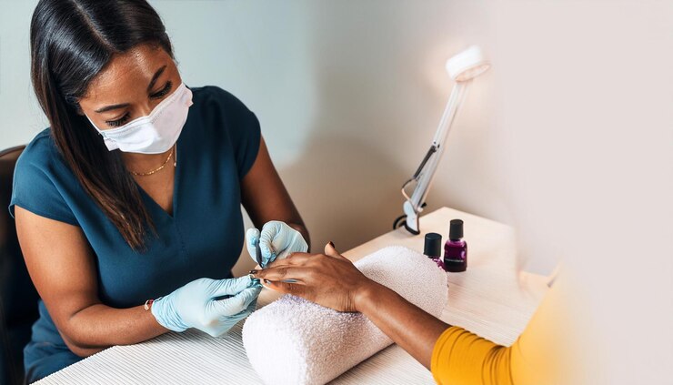 Nail technician using face mask by Fazila via Freepik