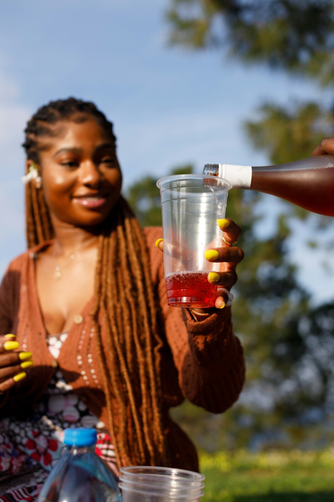 Close-up of wine pouring into a cup held by a woman by Ben Iwara via Unsplash