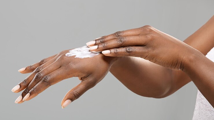 Woman applying sunscreen on hands by Prostock studio via Freepik