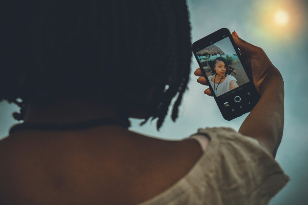 Black girl taking a selfie by Lyrax Vincent via Unsplash 