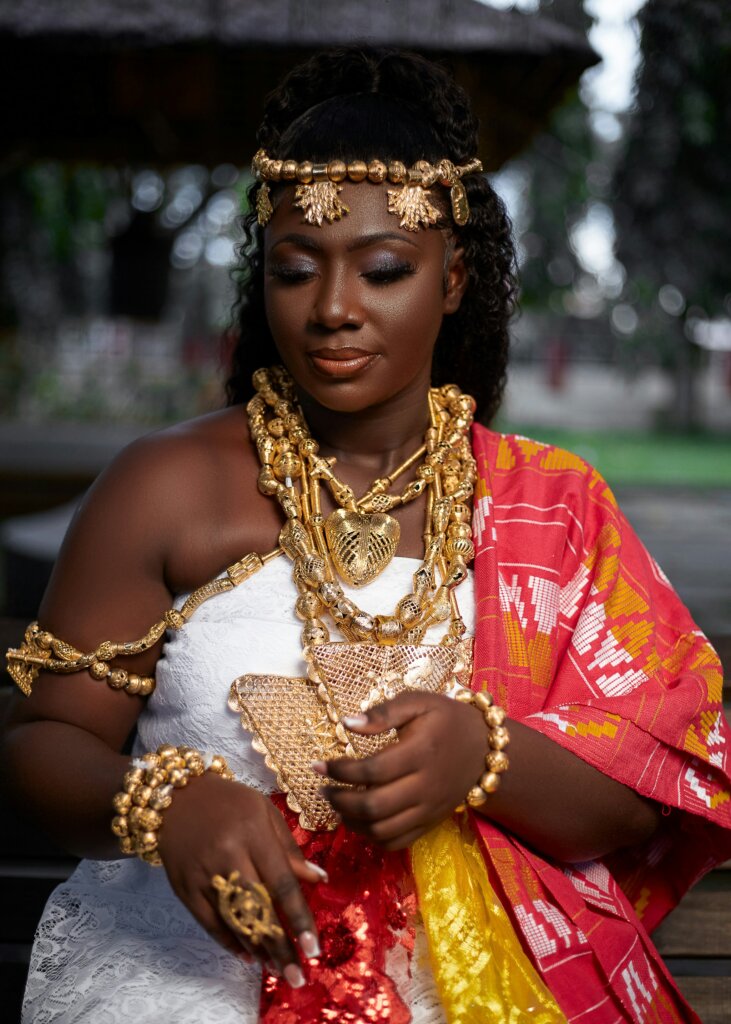 Ghanaian woman wearing gold jewellery by Qwerqu Mcbrew via Unsplash
