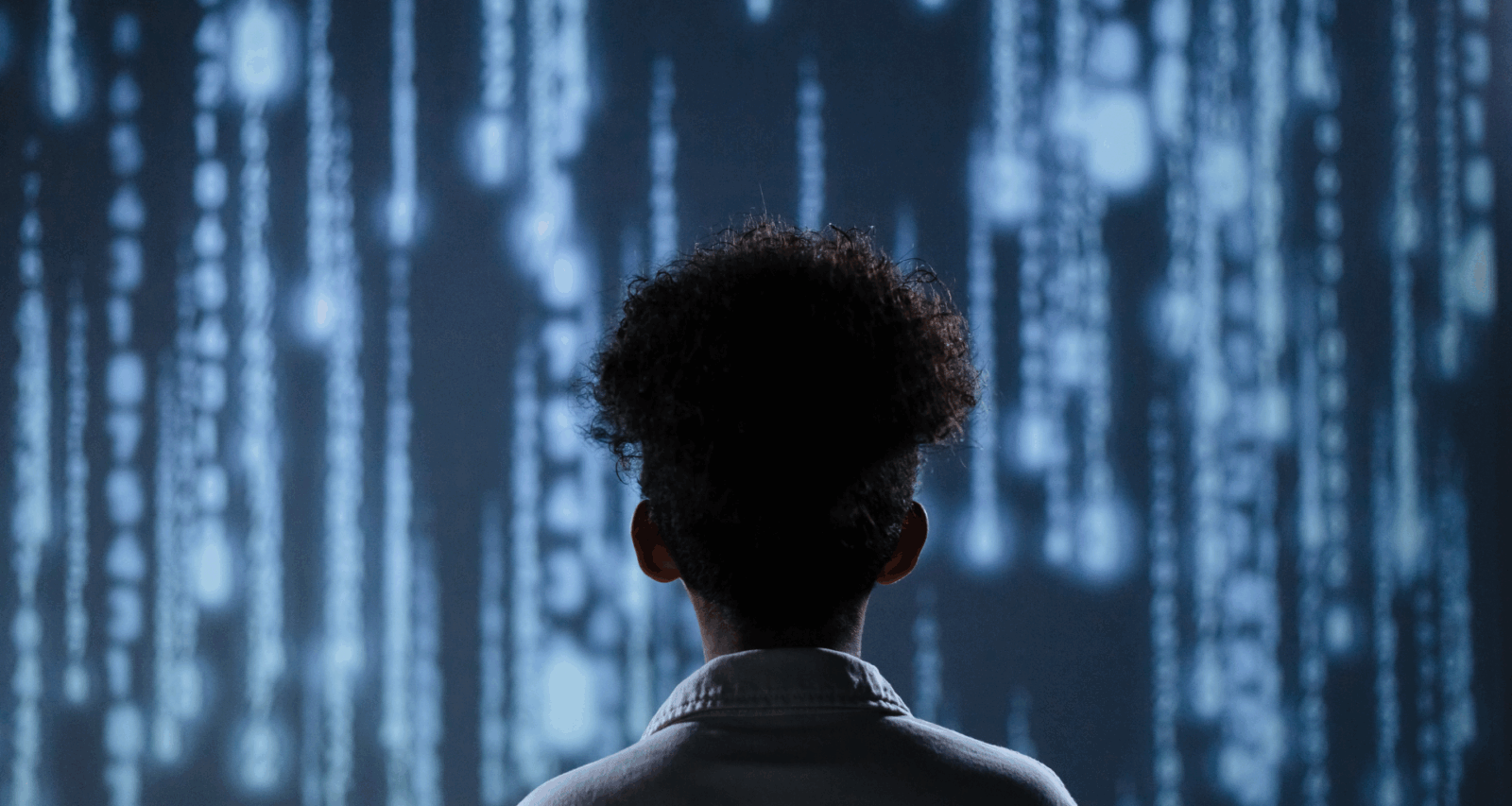 A woman's back view with the lights of AI processing units in front of her via Canva