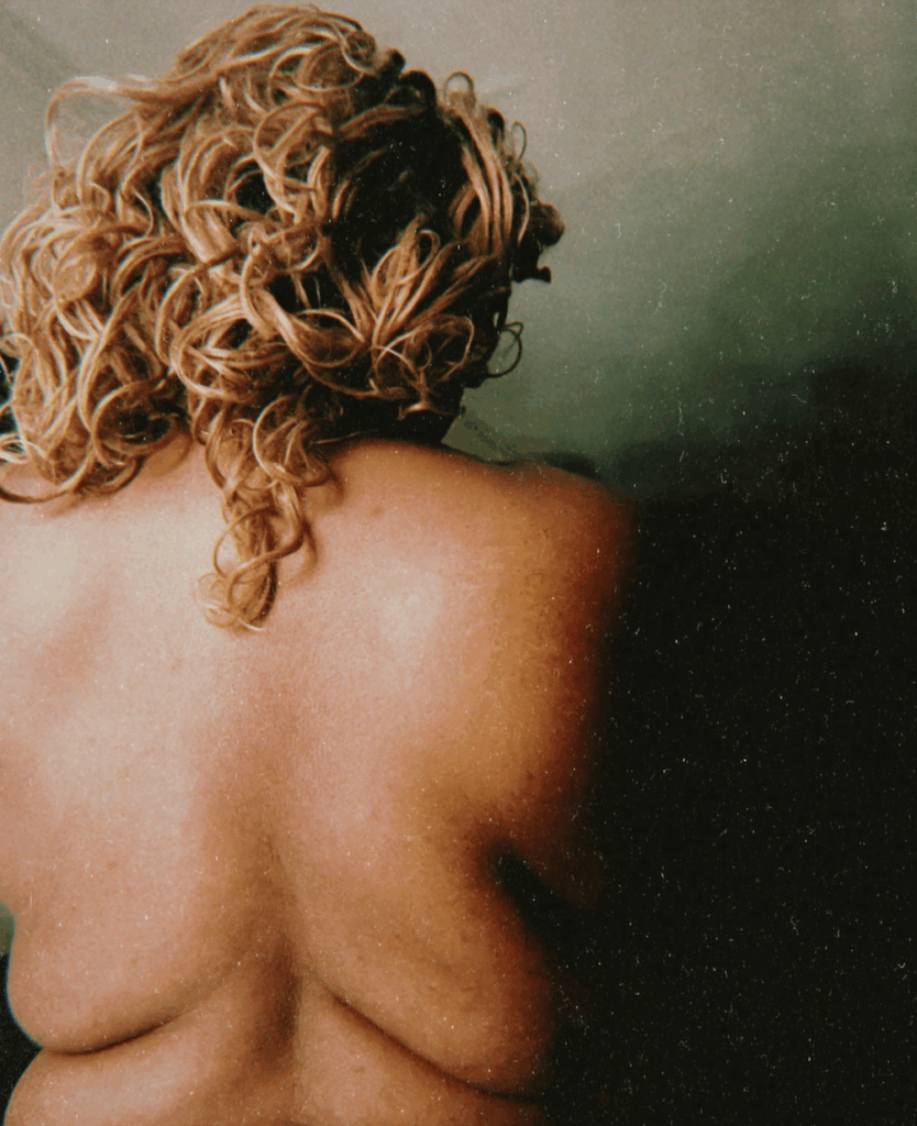 body politics and dysmorphia: Me in 2025. I have braids on. Although I have lost a considerable amount of weight since the past lover saw me, my back remembers their love.