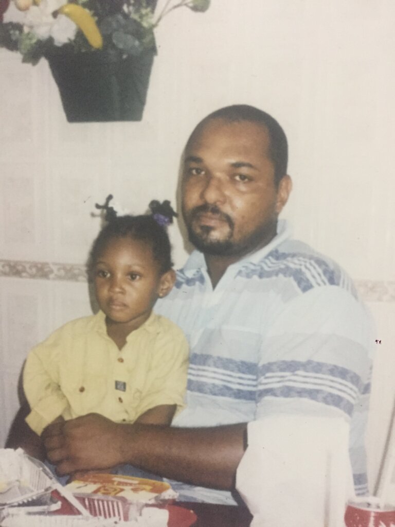 My father, wearing a blue shirt, carrying me, wearing a y in his lap at Mr Biggs, formerly at Rumuola junction, Port Harcourt, sometime in 2002/2003.