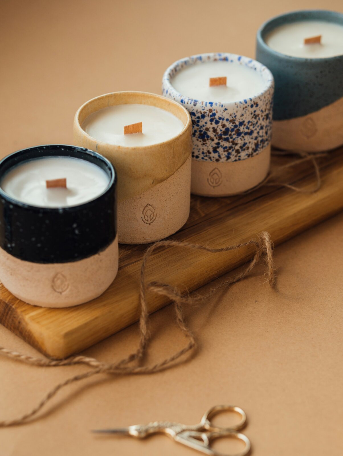 A row of candles in stone jars by Hanna Balan via Unsplash
