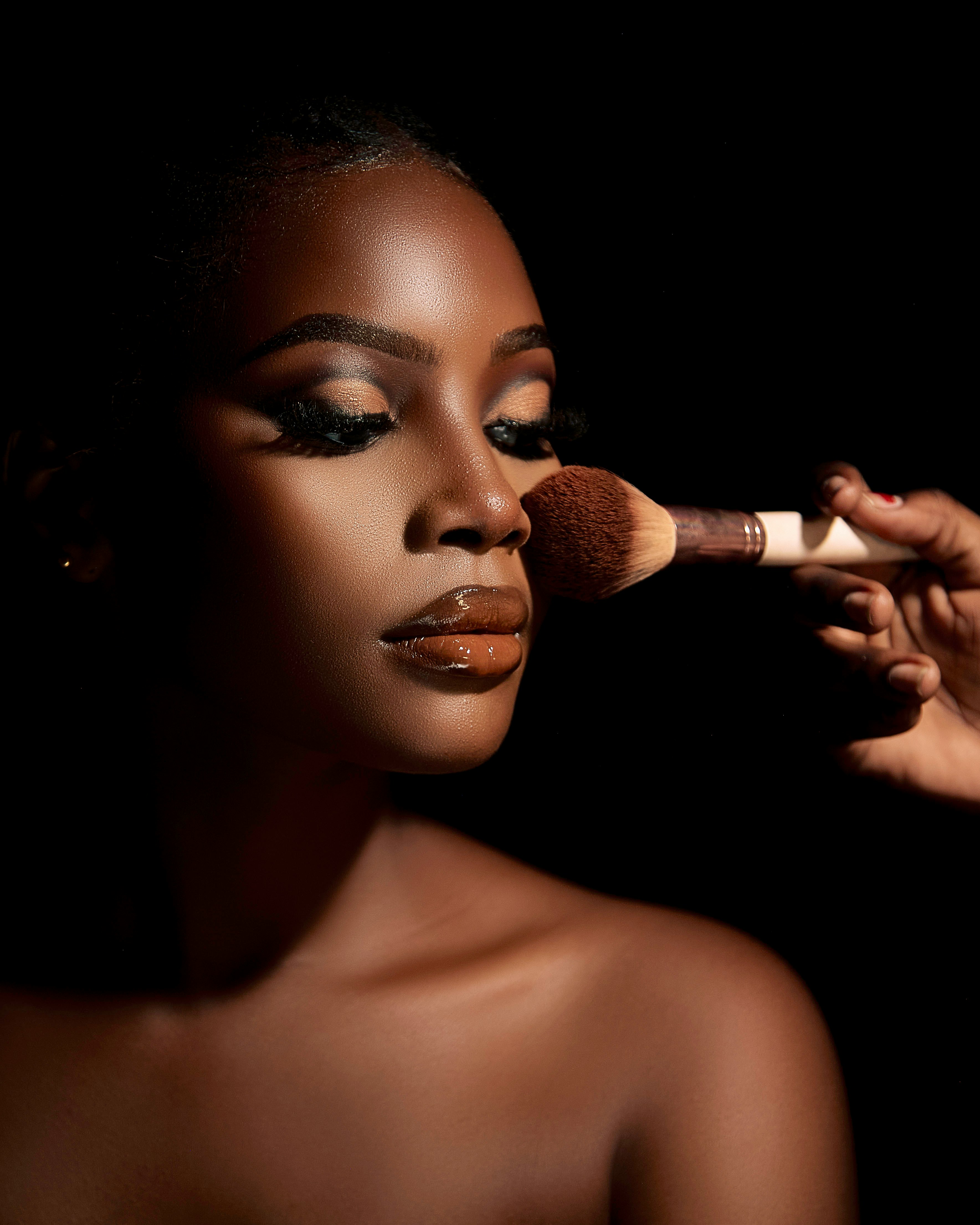 The cost of beauty- model posing with professional makeup. Photo by Qwerqu McBrew via Unsplash