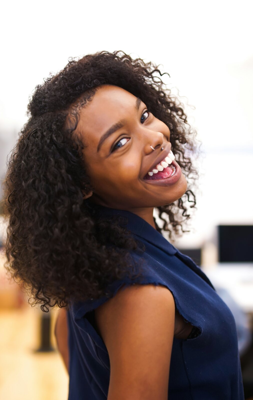 A happy black woman displaying happiness via Isaiah McClean via Unsplash