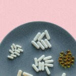 A plate containing a spread of supplements, flanked on either side by a knife and fork via Unsplash