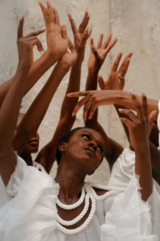 Black woman as divine; Black women wearing white with their hands in the air via Pinterest