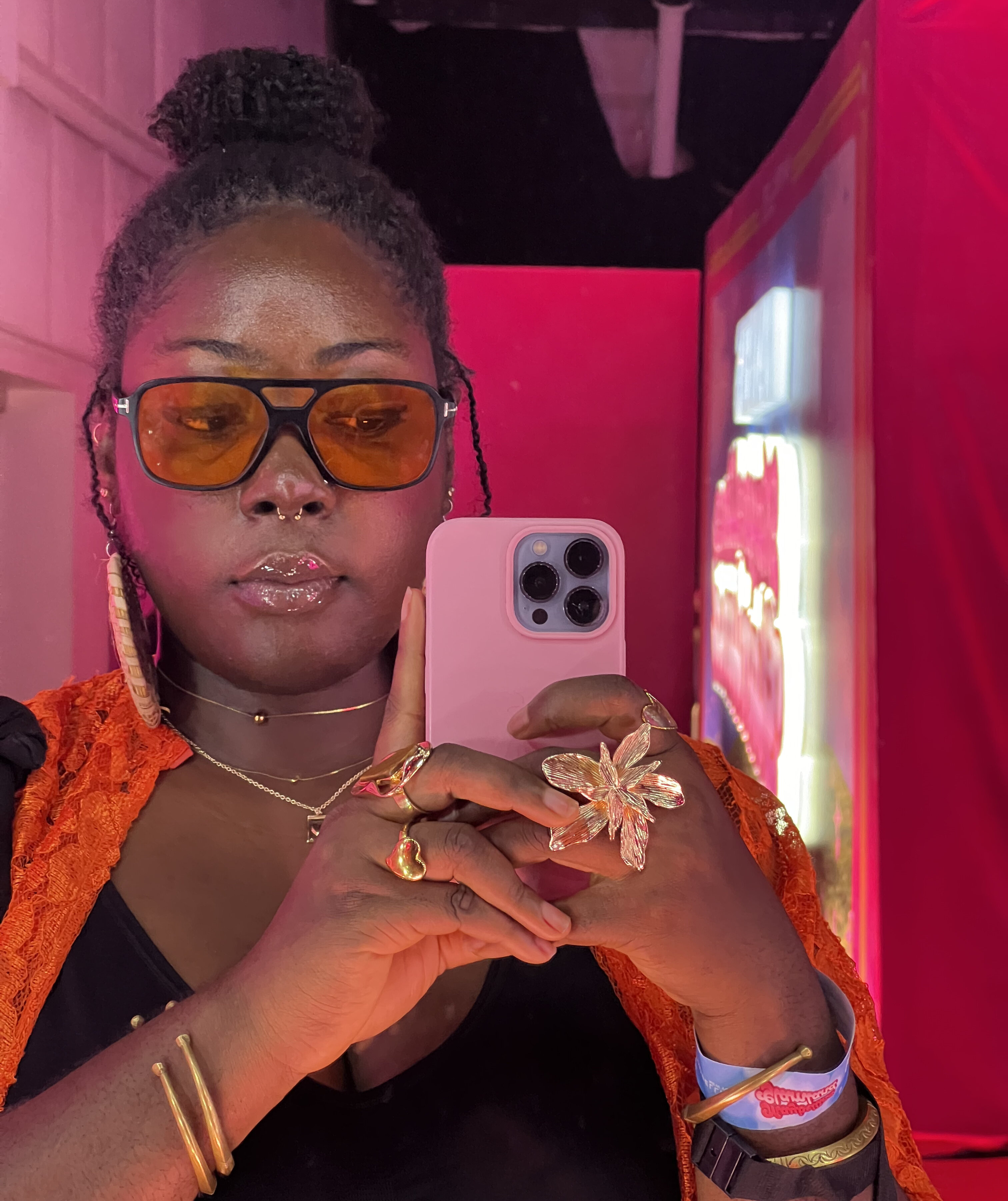 Tobi Afolabi in a mrirror selfie; her locs are up in a bun and she's staring her hr reflection on the phone via Tobi Afolabi