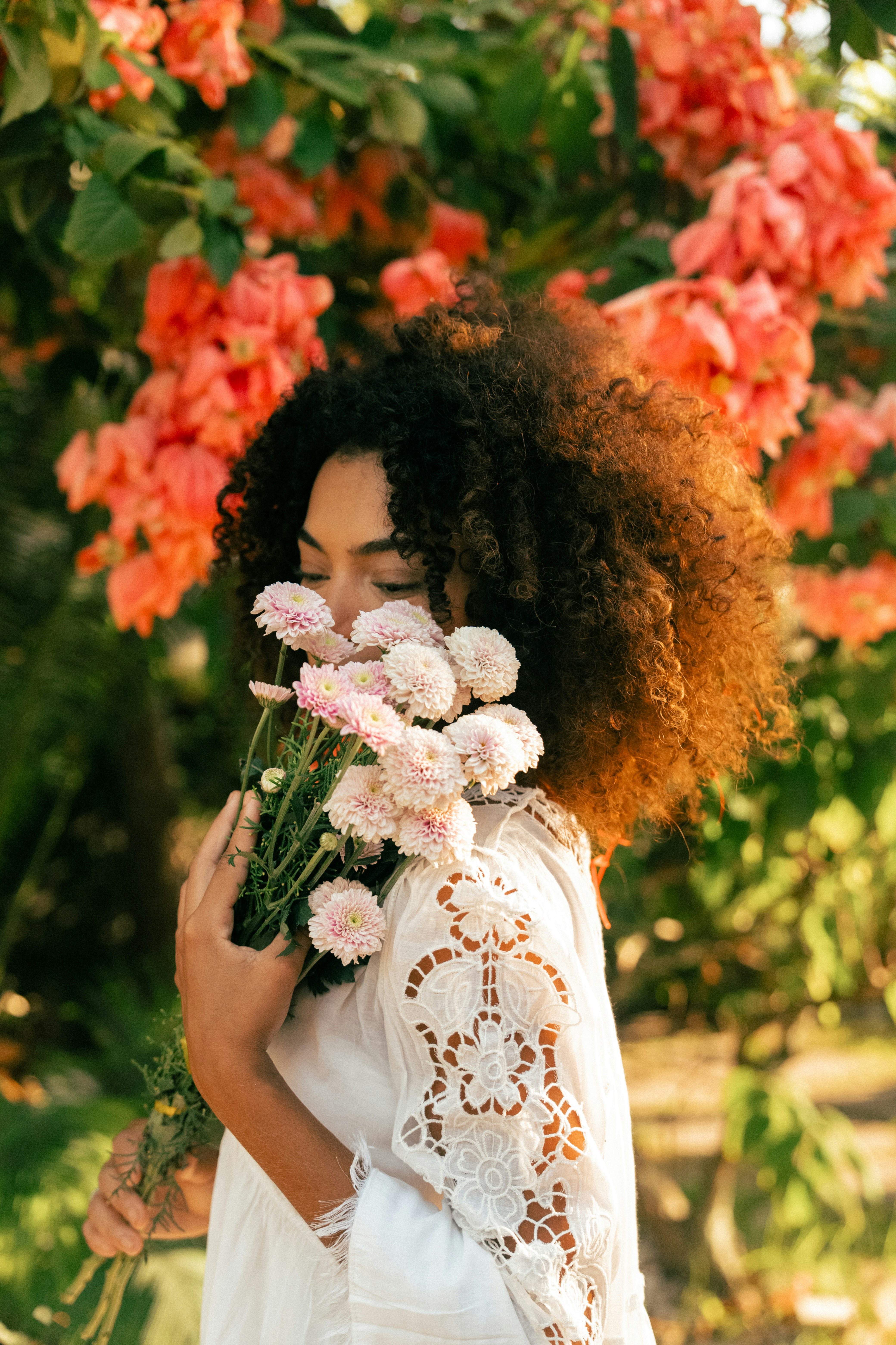 My beauty confessions : Woman standing in front of a bush with flowers by Fellipe Ditadi via unsplash