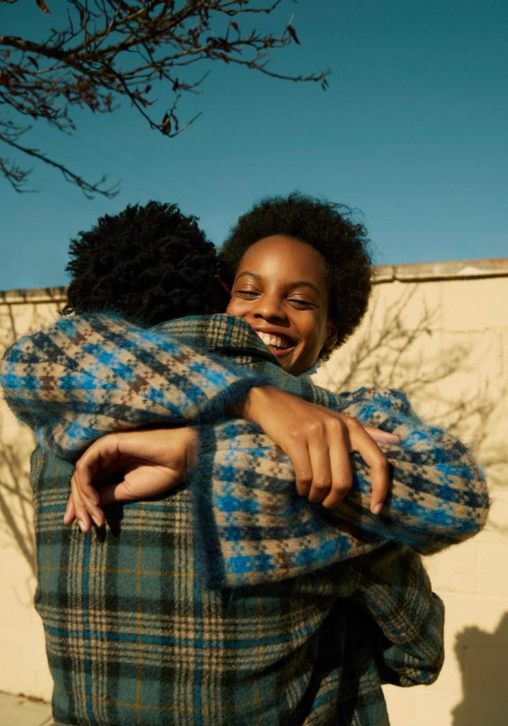 Two black people hugging, with the woman smiling via Pinterest