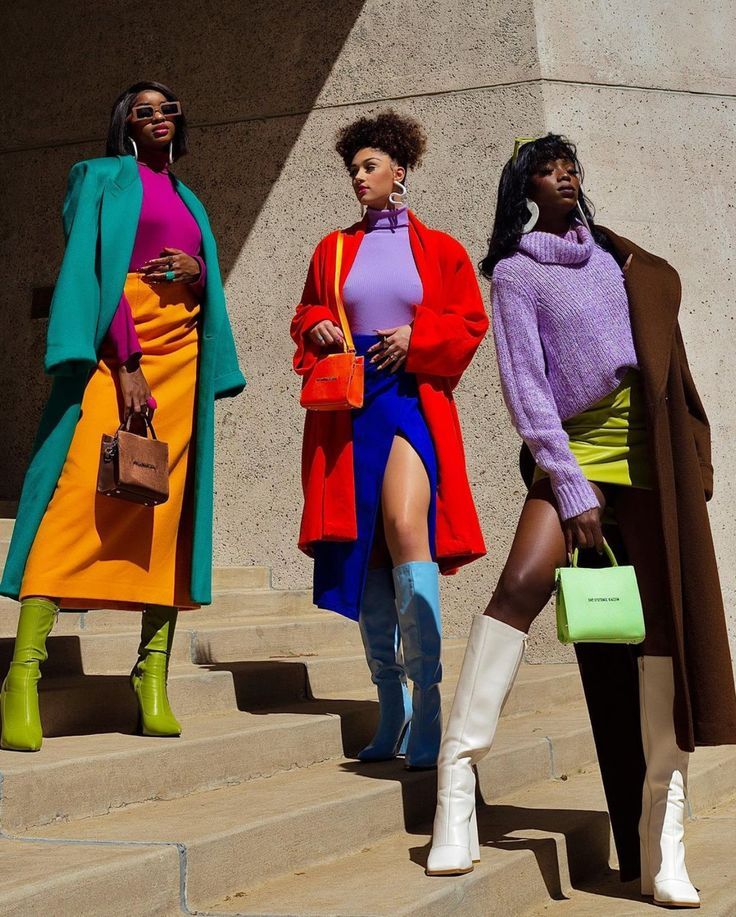 Three stylish black women in colourful clothing pose on stairs via Pinterest