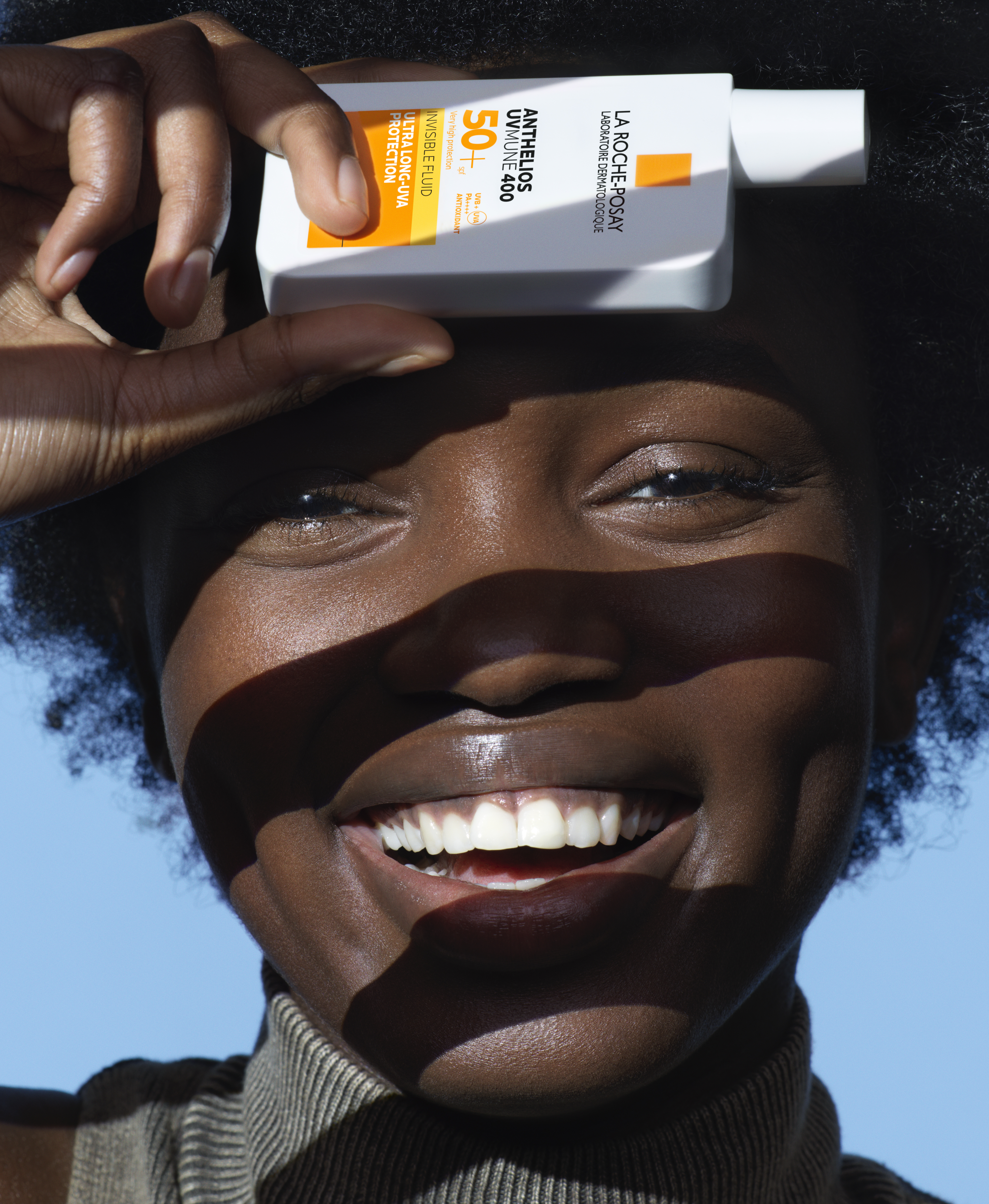 Woman holding La Roche-Posay Anthelios UVMUNE 400 sunscreen