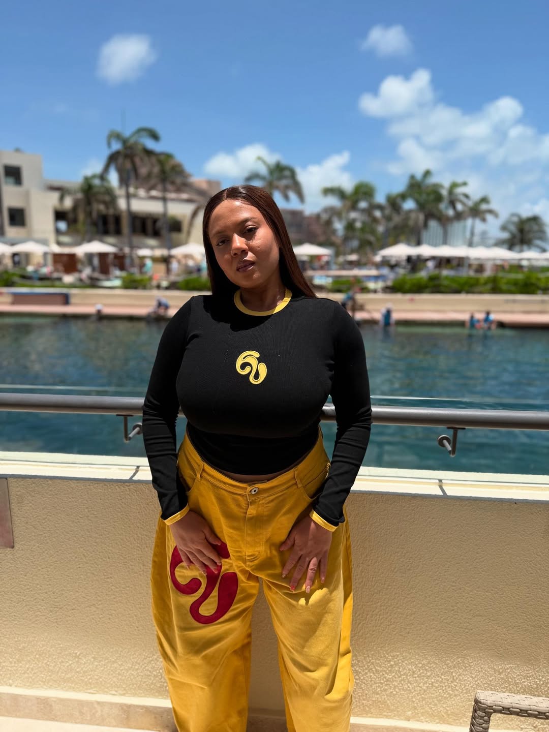 Mariam Bakre in a black blouse and yellow pants via @mory_coco on Instagram.