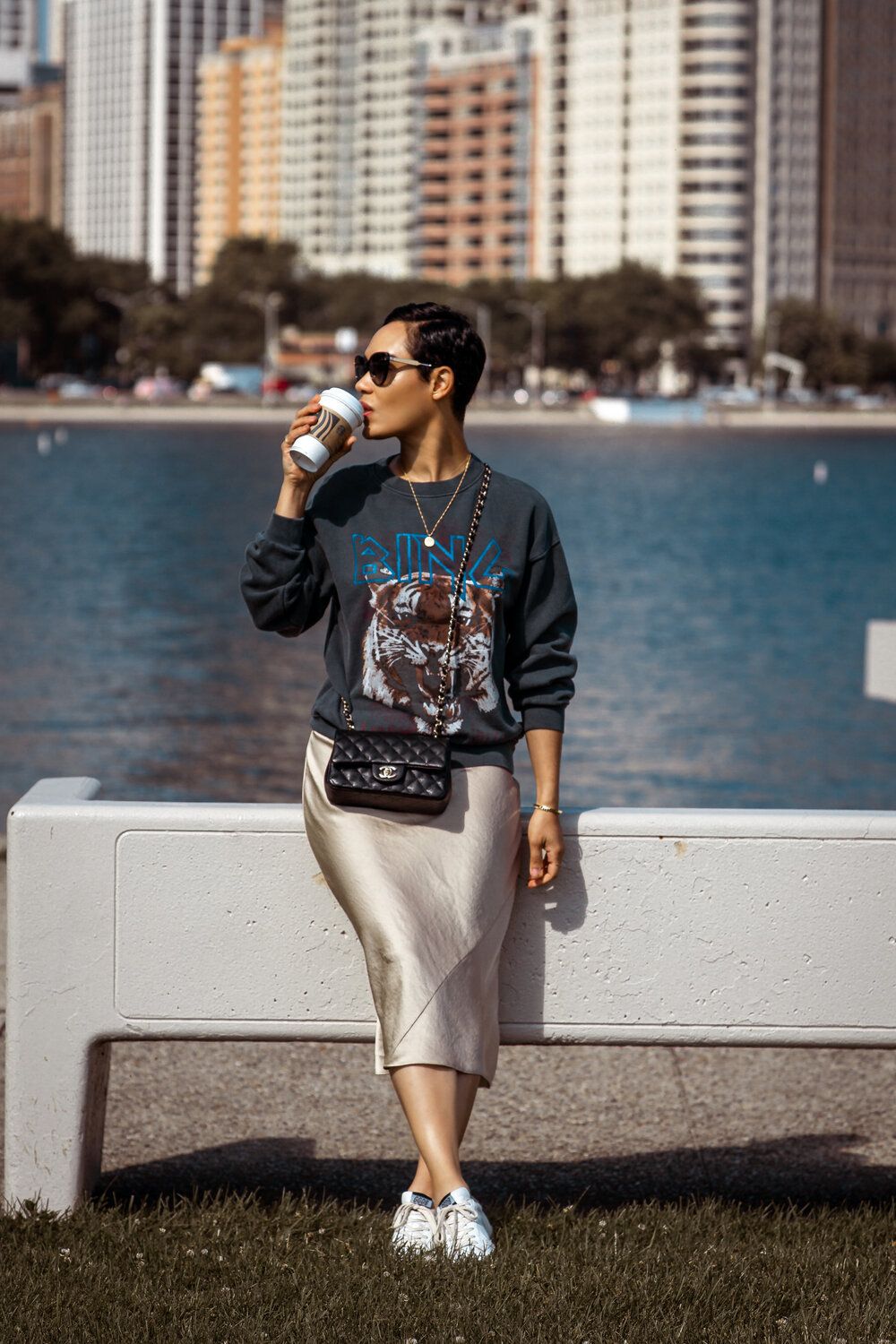 Grace Byers wearing the Anine Bing tiger sweatshirt and a silk midi skirt via ladygracebyers.com.
