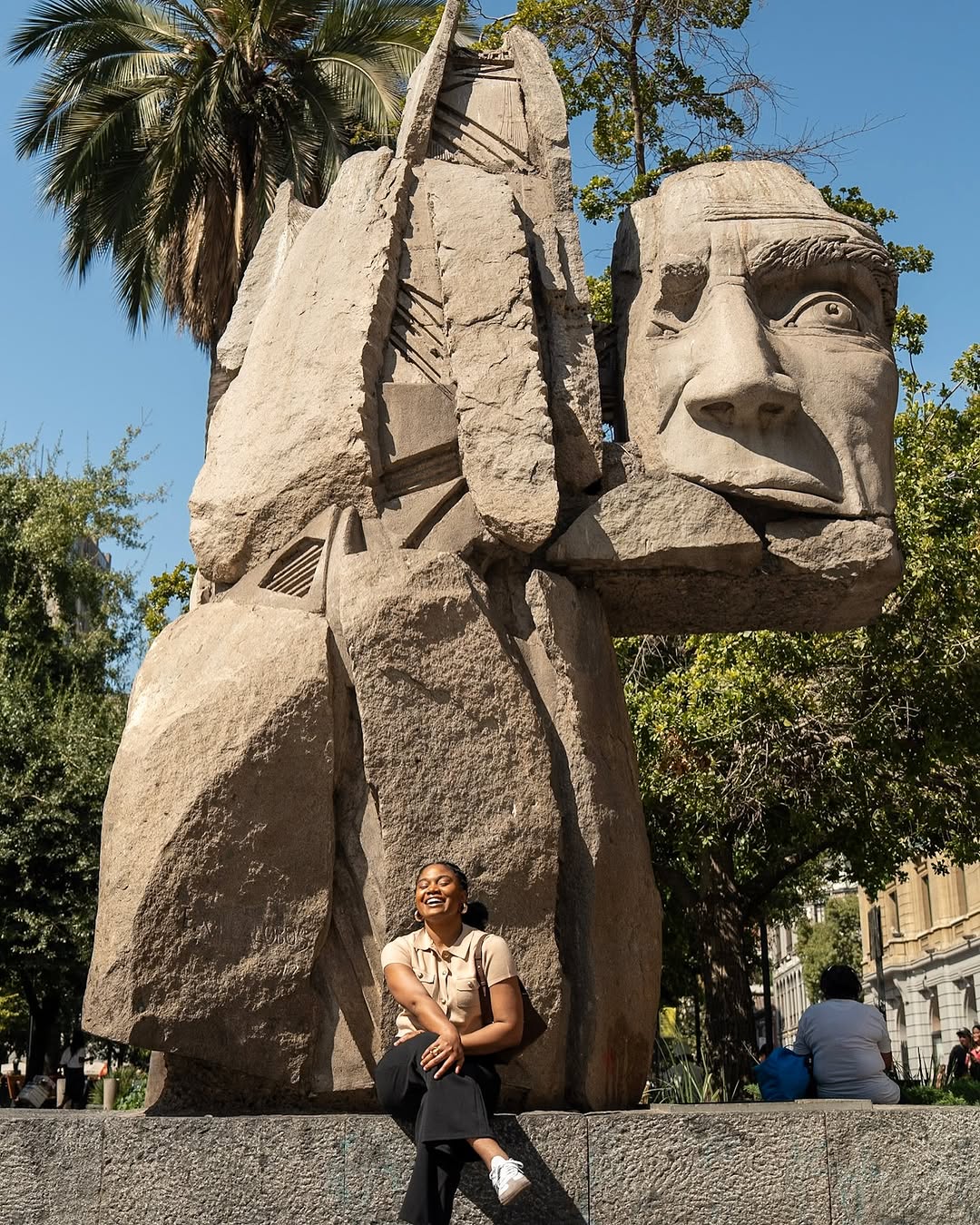 Alma Asinobi posing in front of the rock statue in Chile by Ken Ota