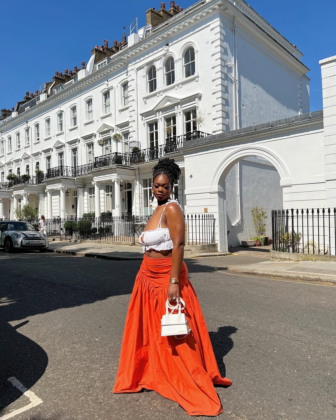  2025 fashion trends -Kike AJ wearing a white crop top and orange maxi skirt via @kikeaj_ on Instagram.