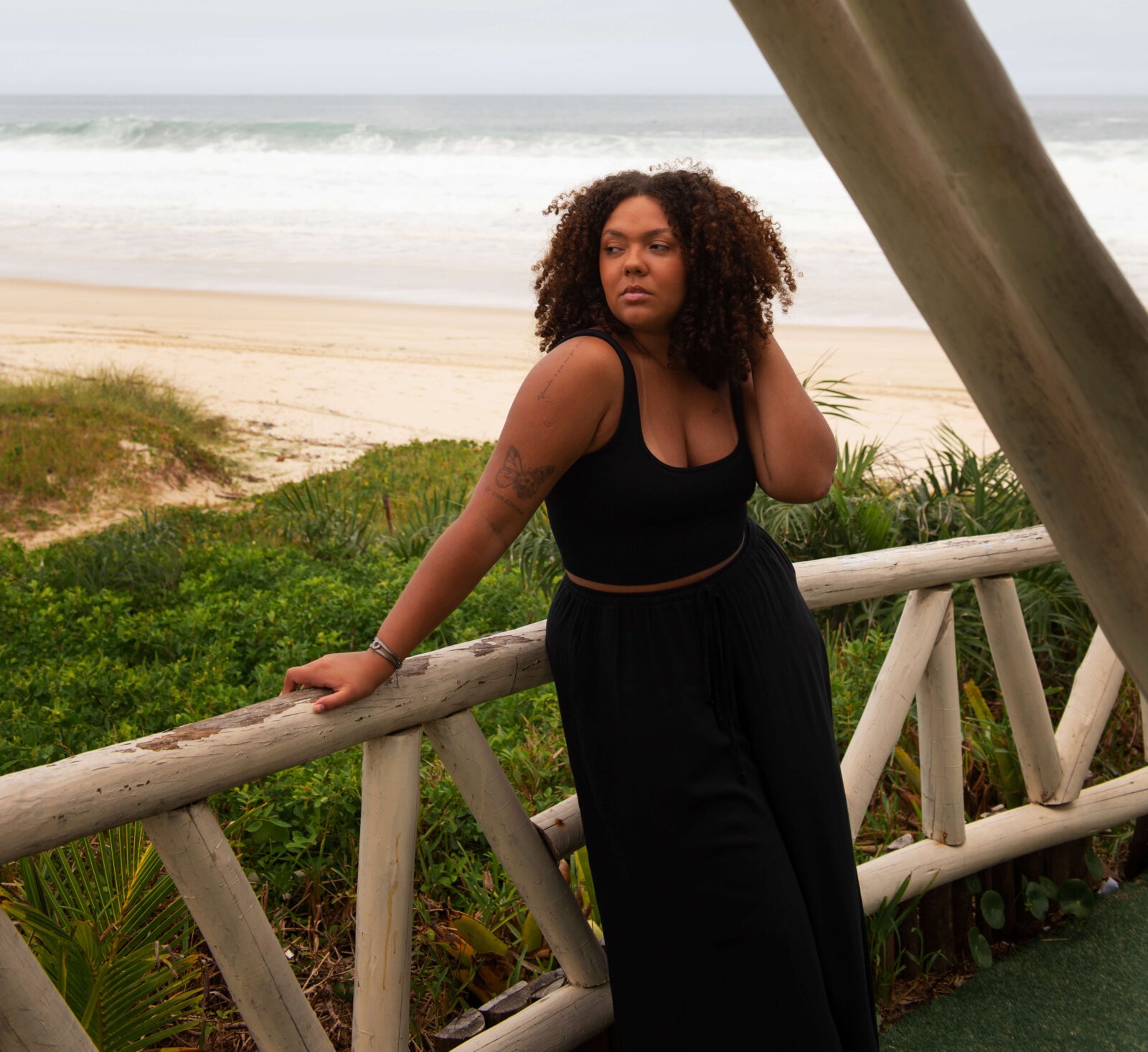 Black woman leaning against a bridge via Freepik