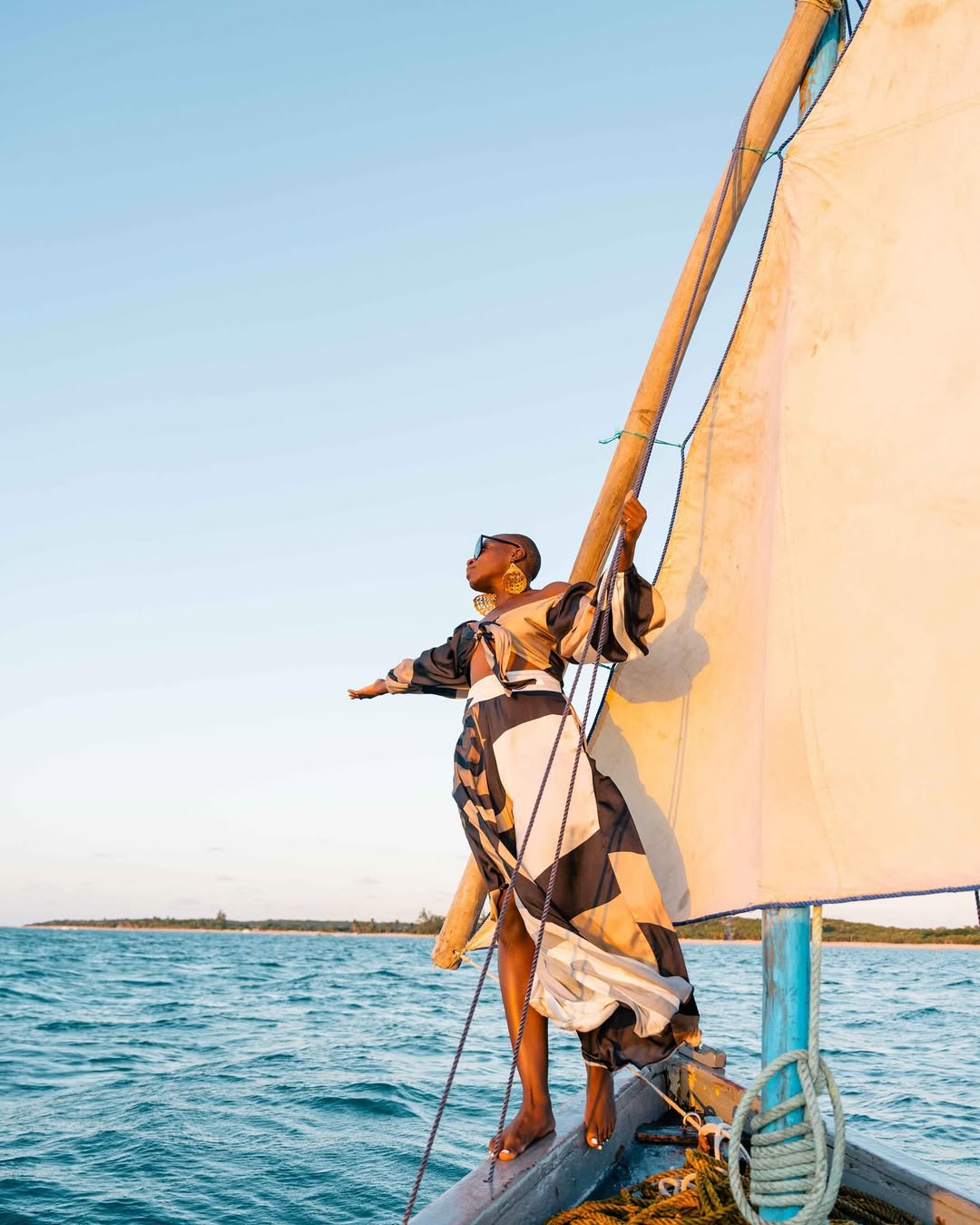 Jessica Nabongo, standing on a boat via @Jessicanabongo on Instagram