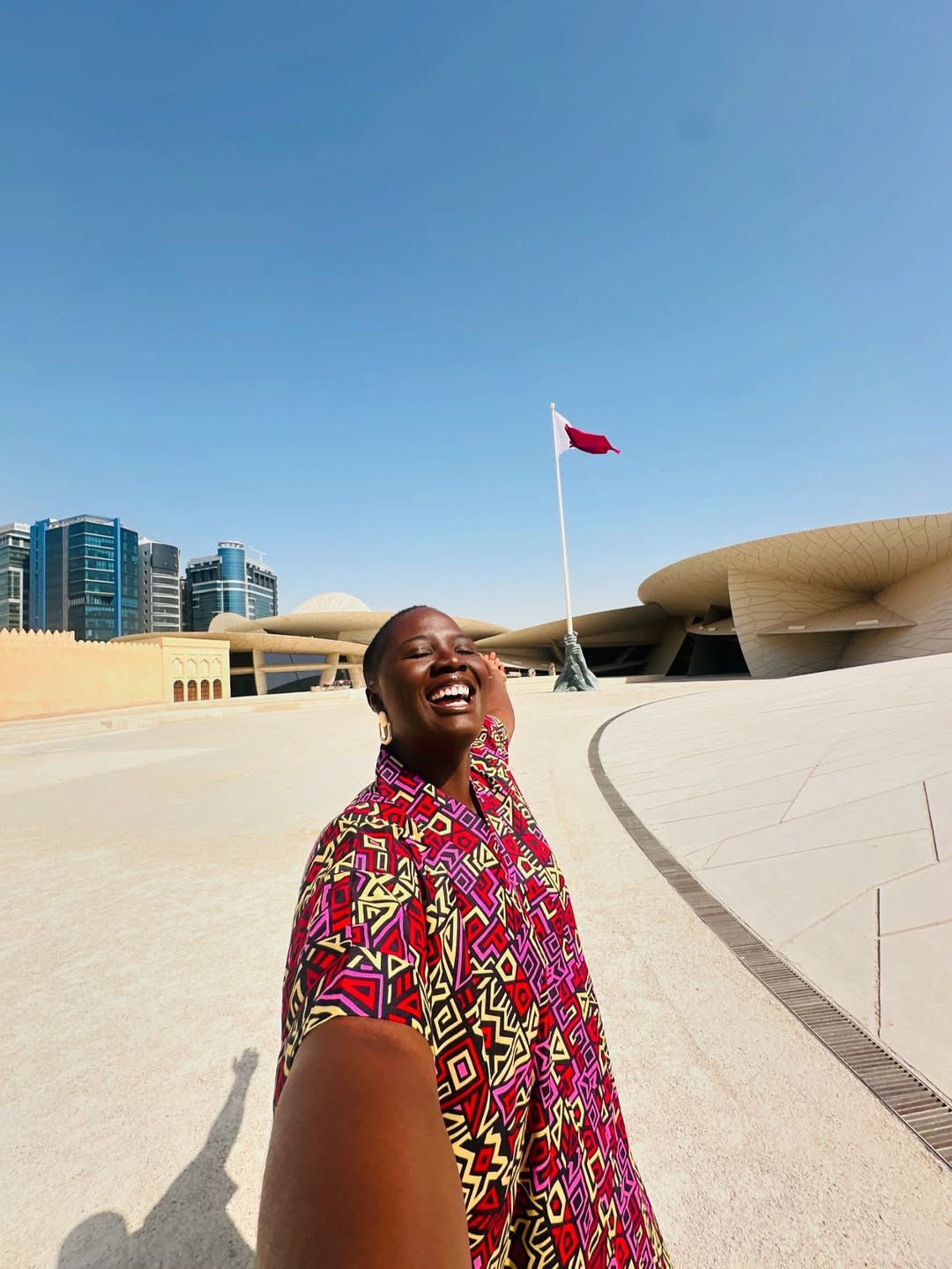 Pelumi Nubi taking a selfie in front of Qatar’s national flag via @Pelumi.nubi on Instagram