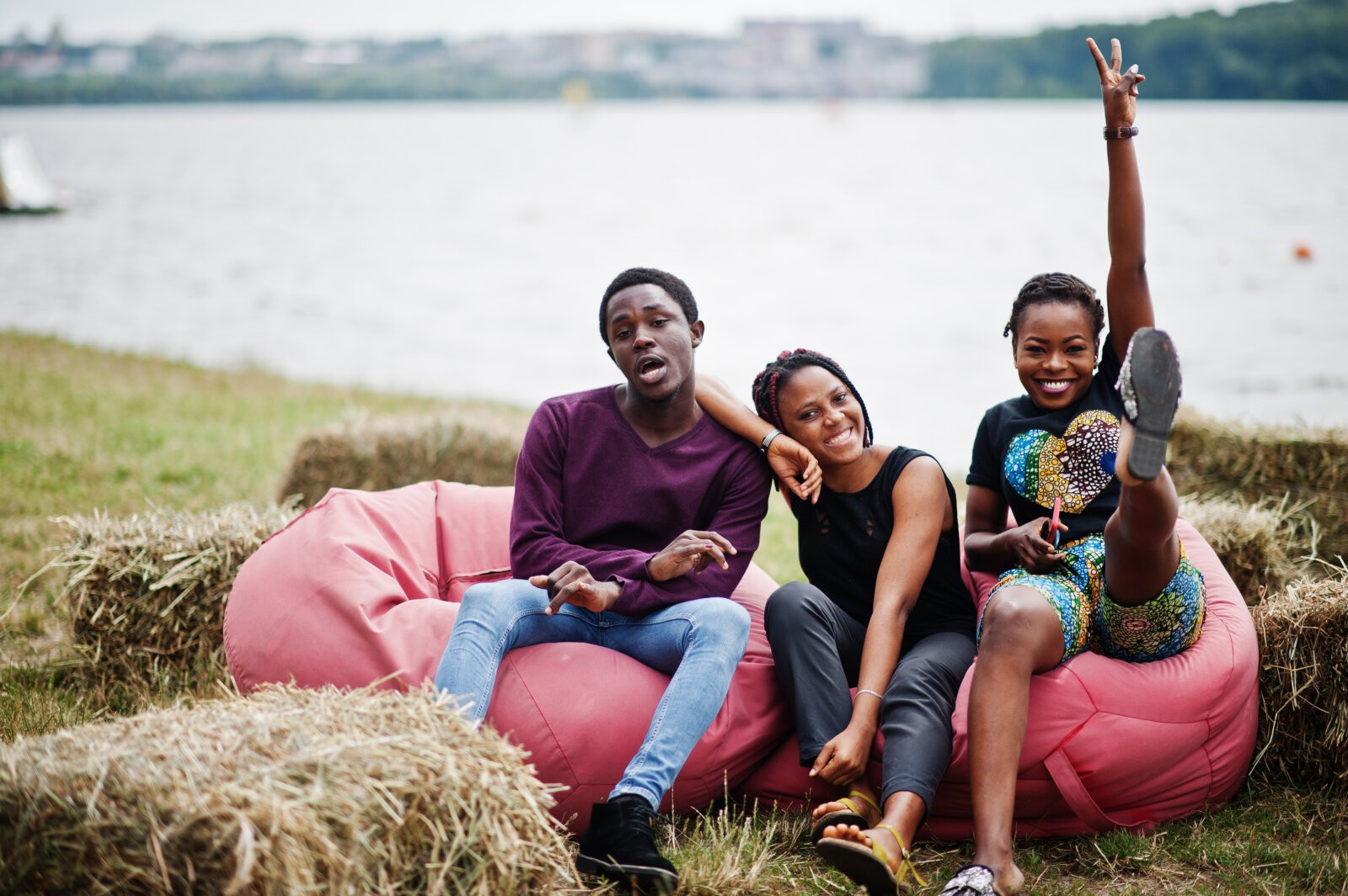 Siblings sitting together on inflatable chairs in front of a lake via Freepik
