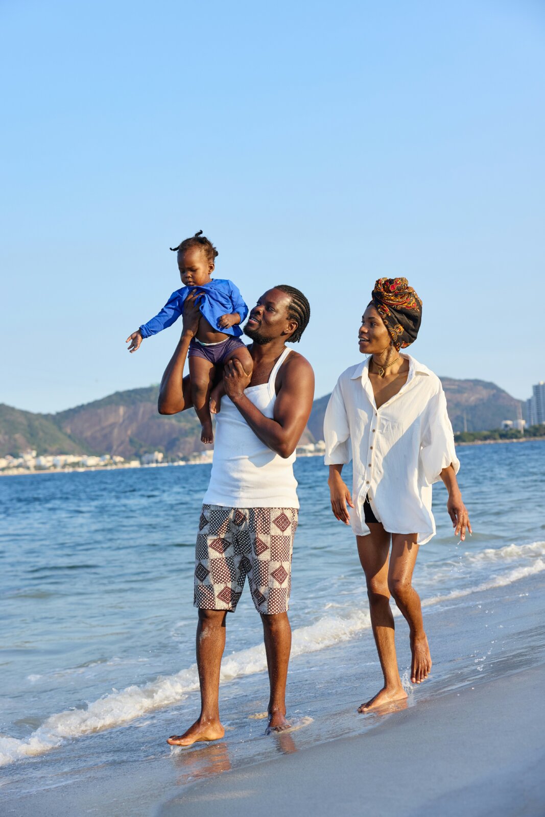 A couple with their baby walking on the beach by Molly the cat via Unsplash
