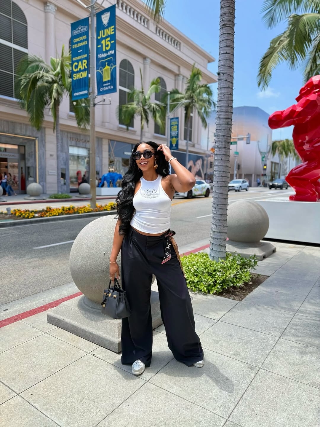 Sharon Ooja Nwoke wearing a white tank top and denim pants via @sharonooja on Instagram.