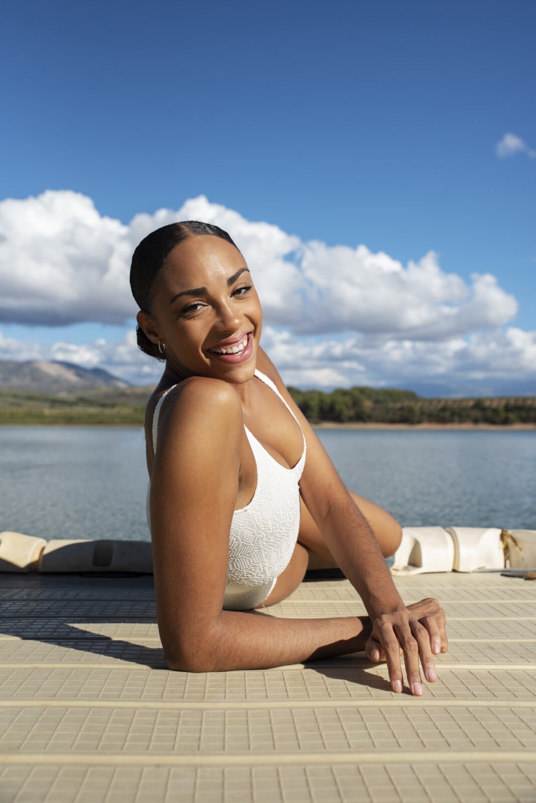 Smiling black woman laying by a lake via Freepik