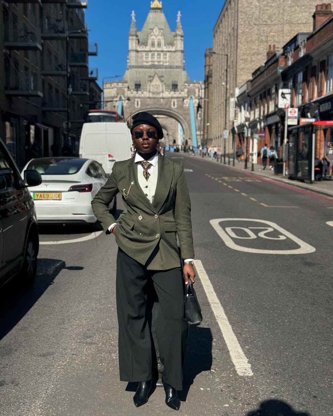 Ifeolu Oladun wearing an army green suit, black trousers and beret @beehigeehh on Instagram.