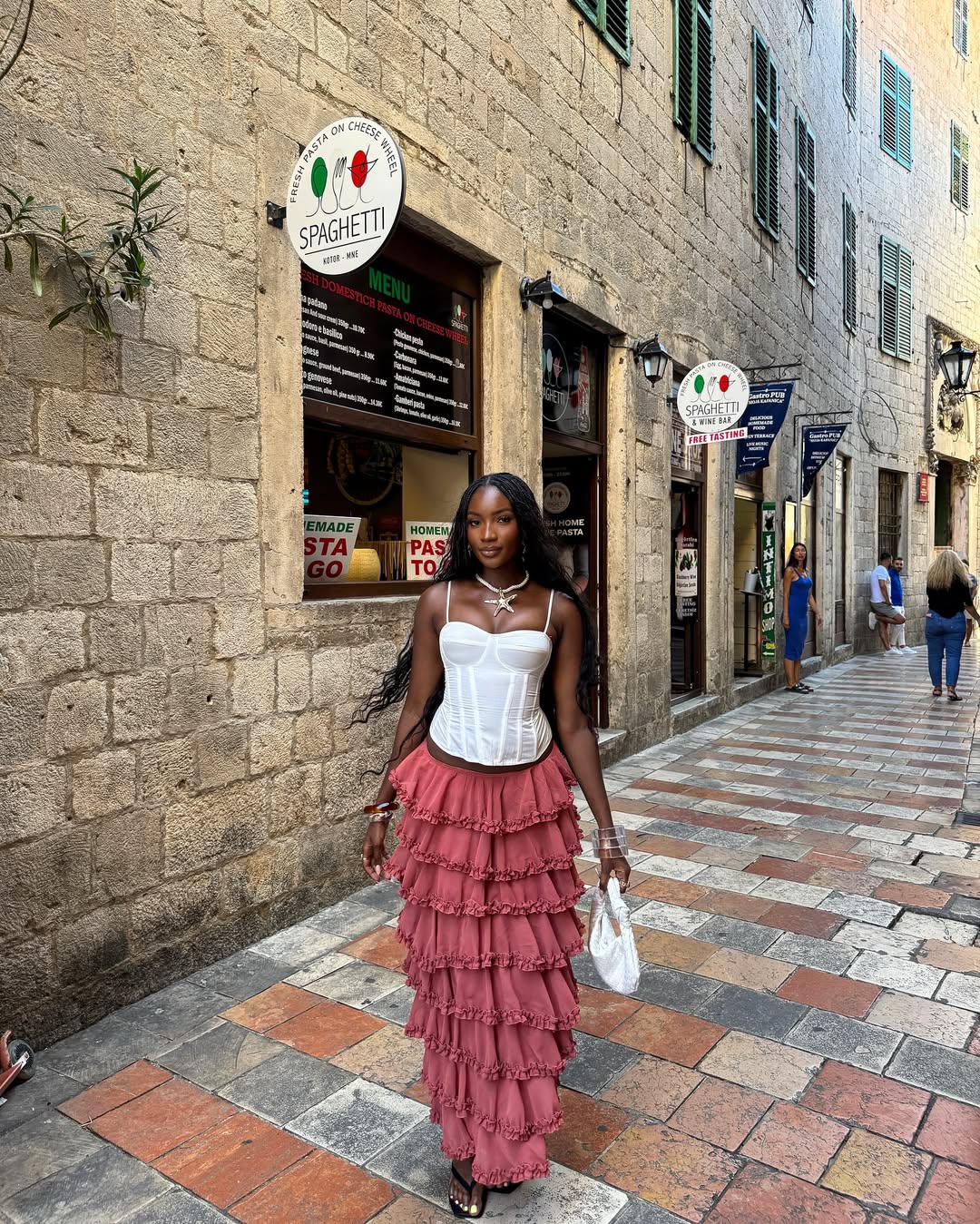 2025 fashion trends- Zainab wearing a white corset top and pink ruffled skirt via @mz_zae on Instagram. 