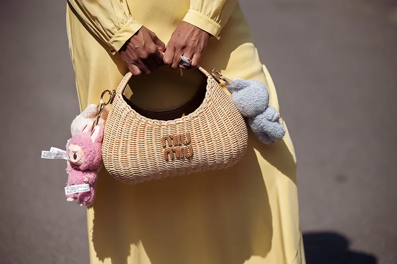 A black woman holding a Miu Miu woven bag with Labubu charms via Getty Images
