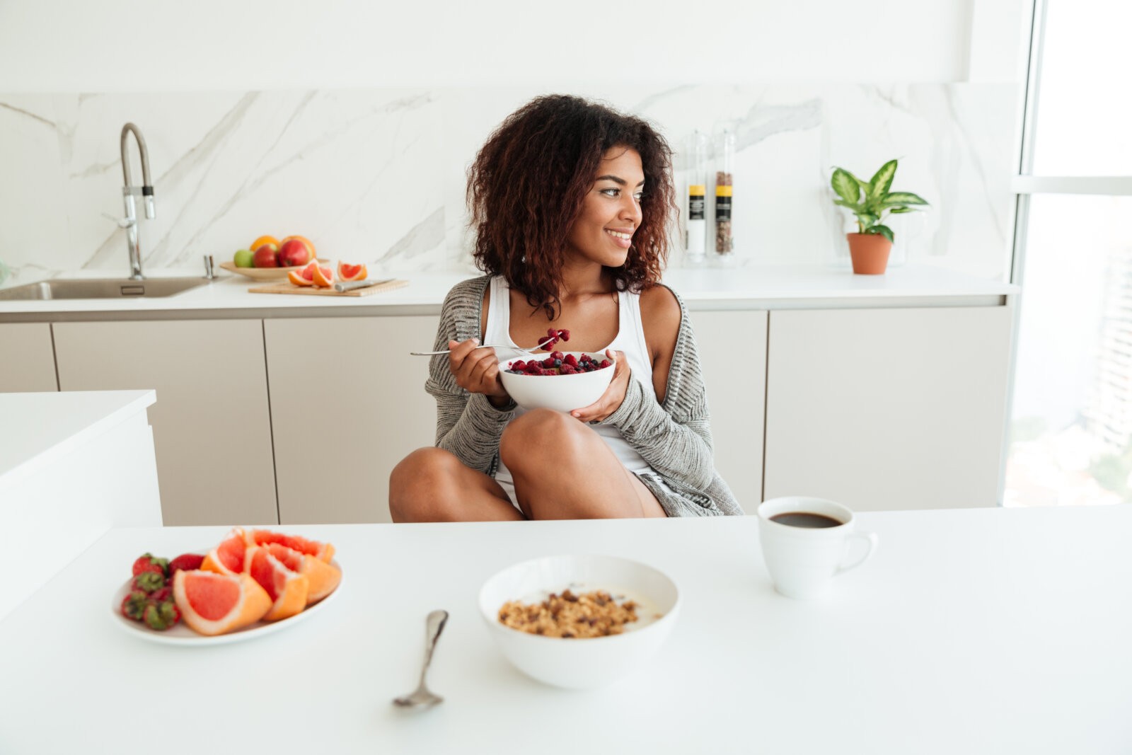 Black woman with a bowl of fruit via Freepik