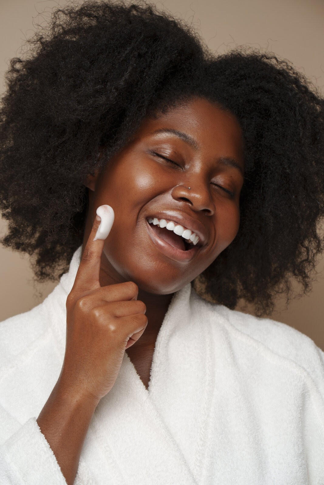 A black woman doing her skincare via Freepik