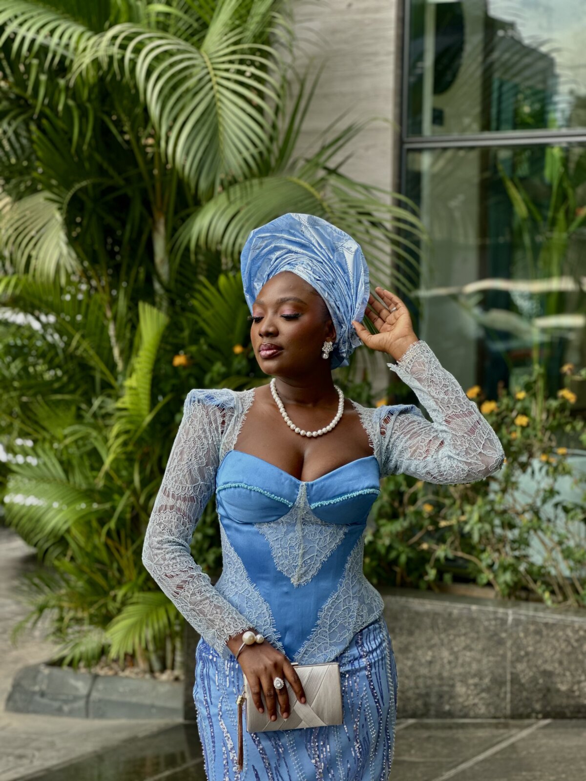 Wumi Tuase-Fosudo in a blue lace two-piece asoebi outfit with pearl jewellery
