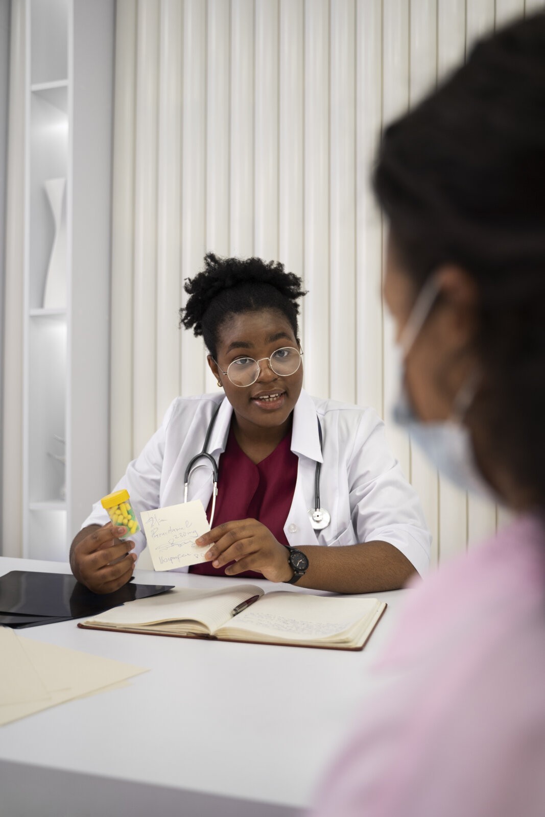  Black female doctor explaining medications to female patient via Freepik