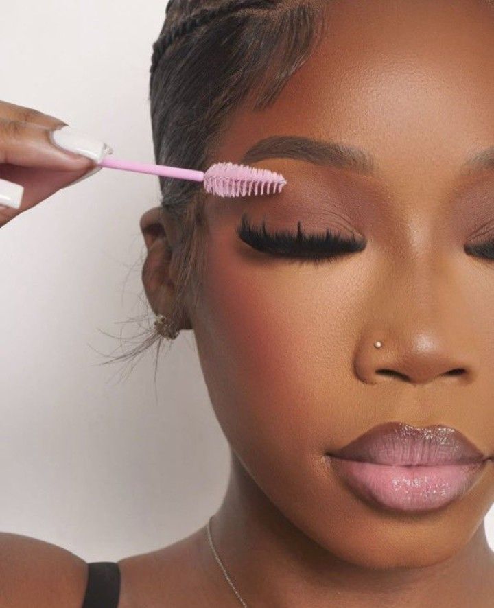 Lash care - Close-up shot of a black woman using a brush via Pinterest